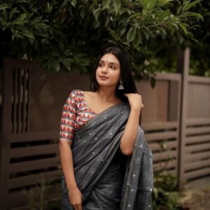 linen with zari weaving chex and allover mirror work.  Tassesls on pallu.